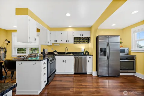 a kitchen with granite countertop a refrigerator and a stove top oven