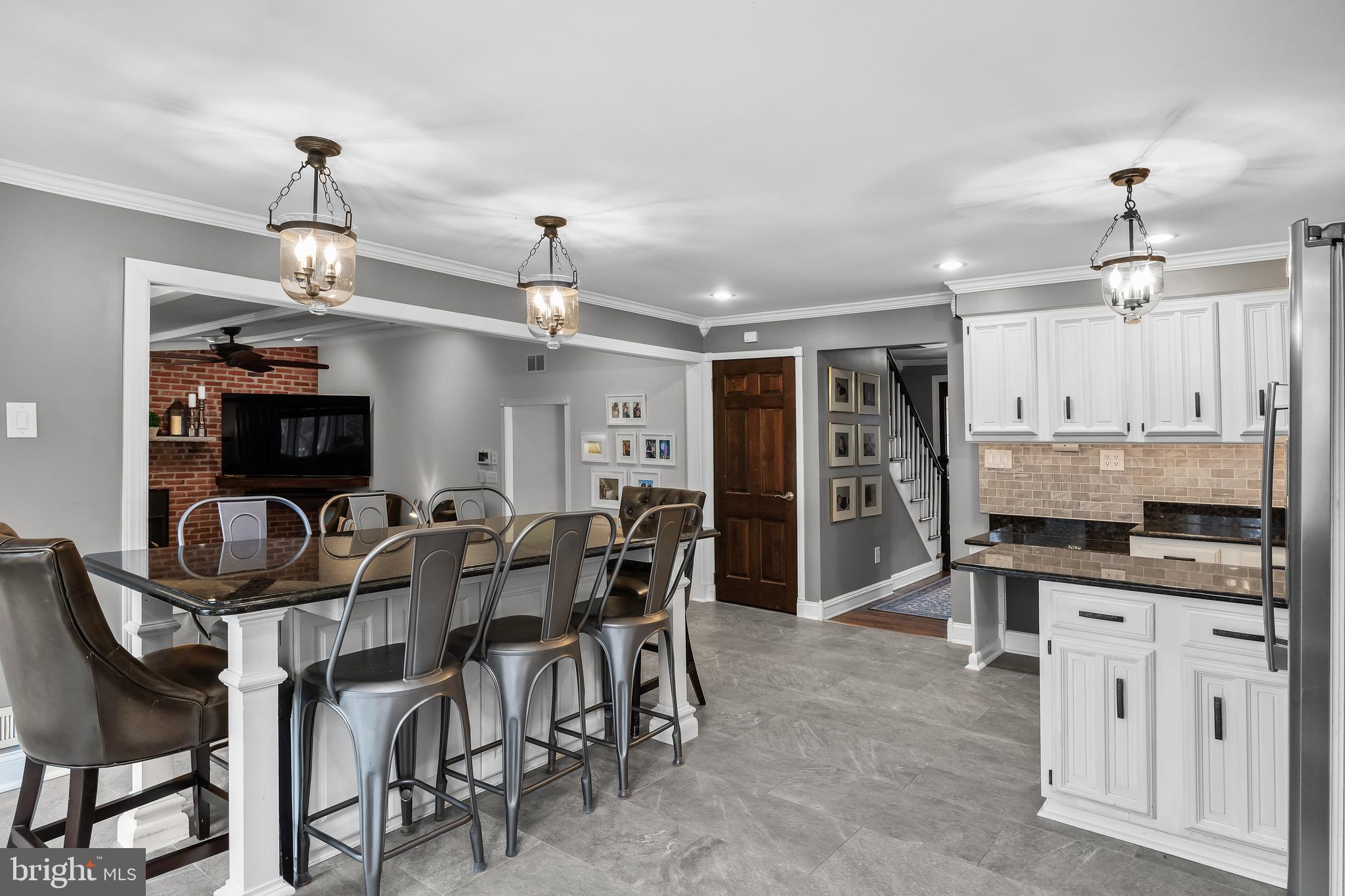 2407 Riverton Road Cinnaminson, NJ 08077 - Photo 15 of 54 a kitchen with stainless steel appliances kitchen island granite countertop a table chairs and a refrigerator