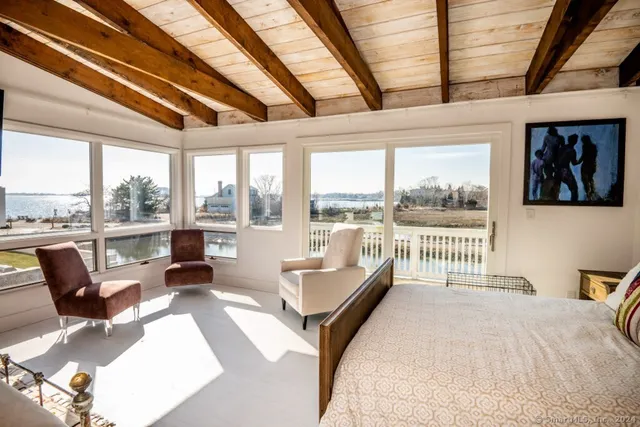 a bedroom with furniture and large windows