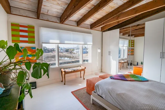 a bedroom with a bed and a potted plant