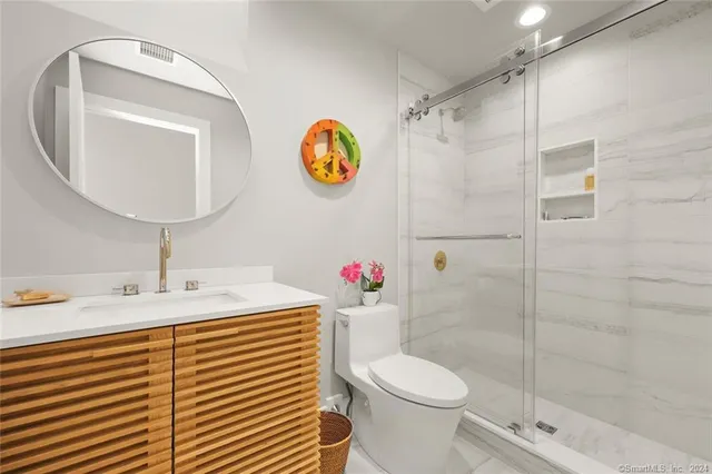 a bathroom with a sink a toilet and shower