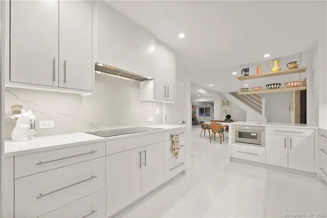 a kitchen with white cabinets and sink