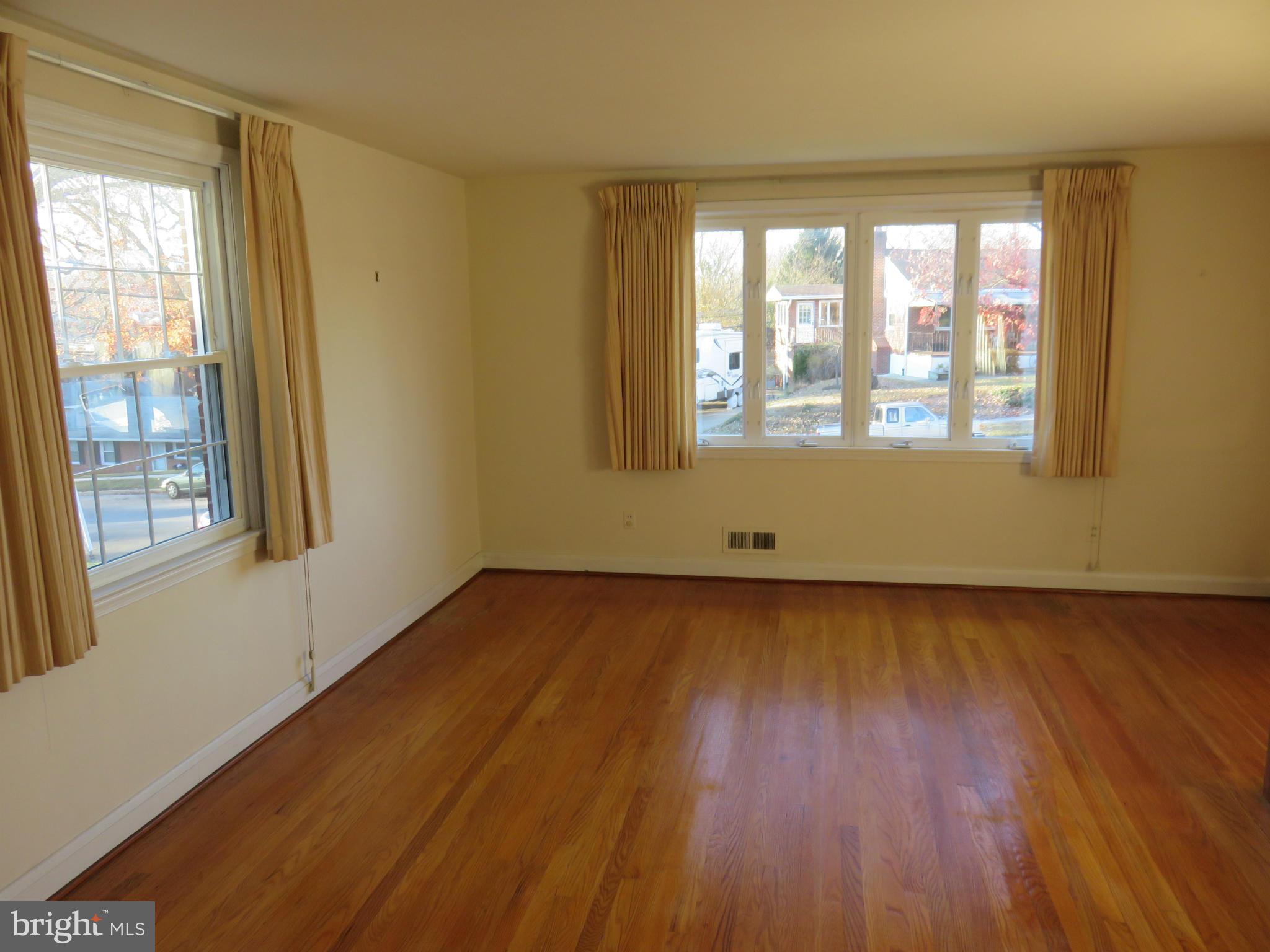 1747 Ellinwood Road Baltimore, MD 21237 - Photo 2 of 26 a view of an empty room with wooden floor and a window