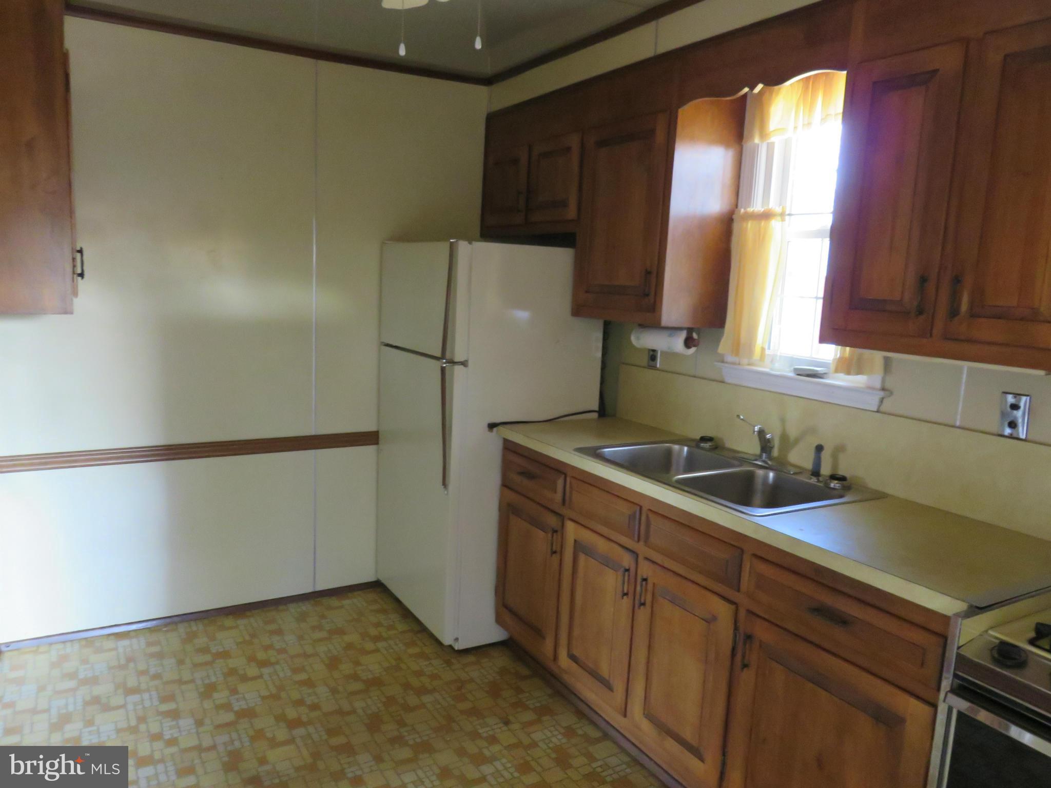 1747 Ellinwood Road Baltimore, MD 21237 - Photo 11 of 26 a kitchen with a refrigerator sink and cabinets