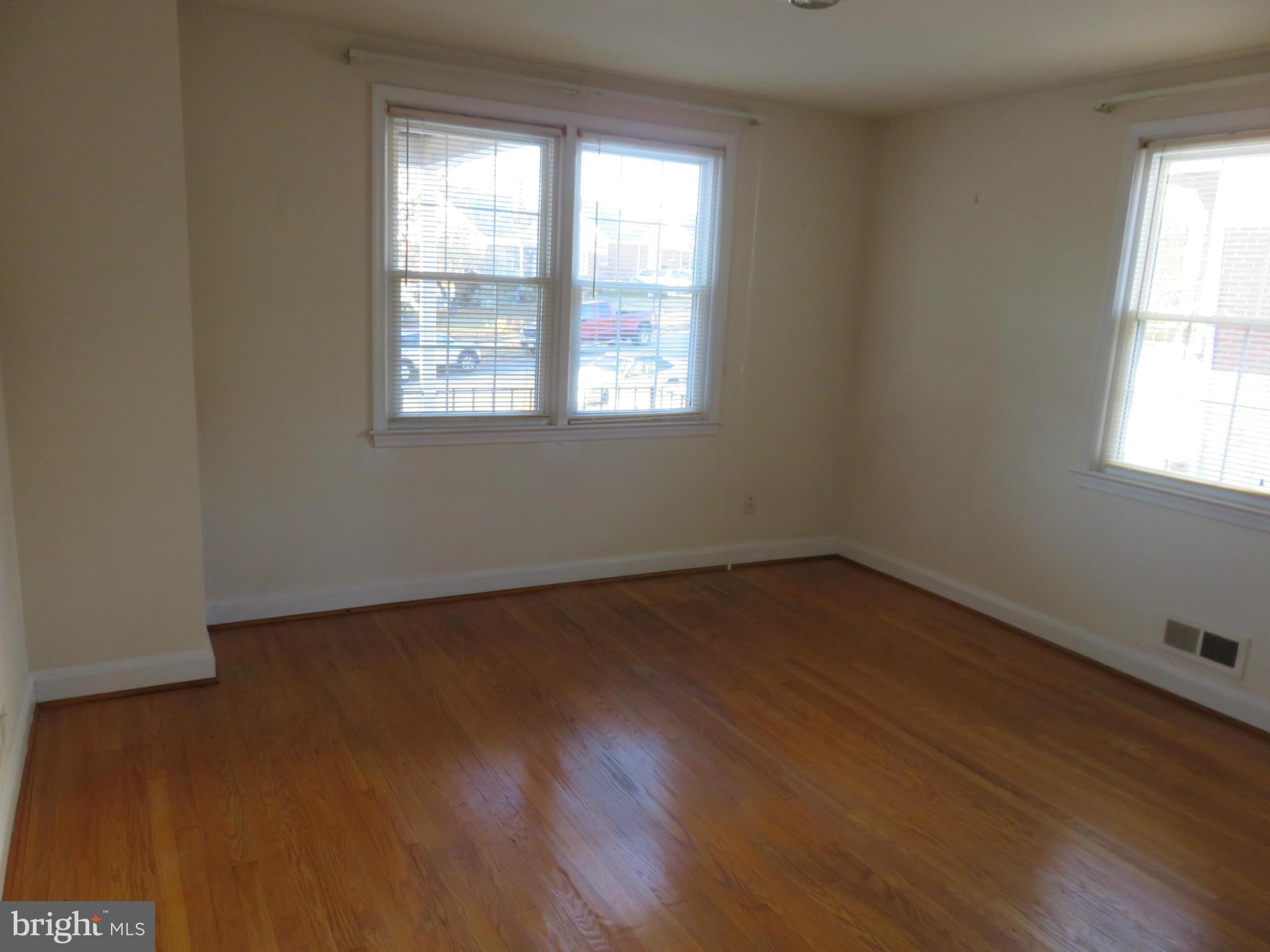 1747 Ellinwood Road Baltimore, MD 21237 - Photo 13 of 26 an empty room with wooden floor and windows