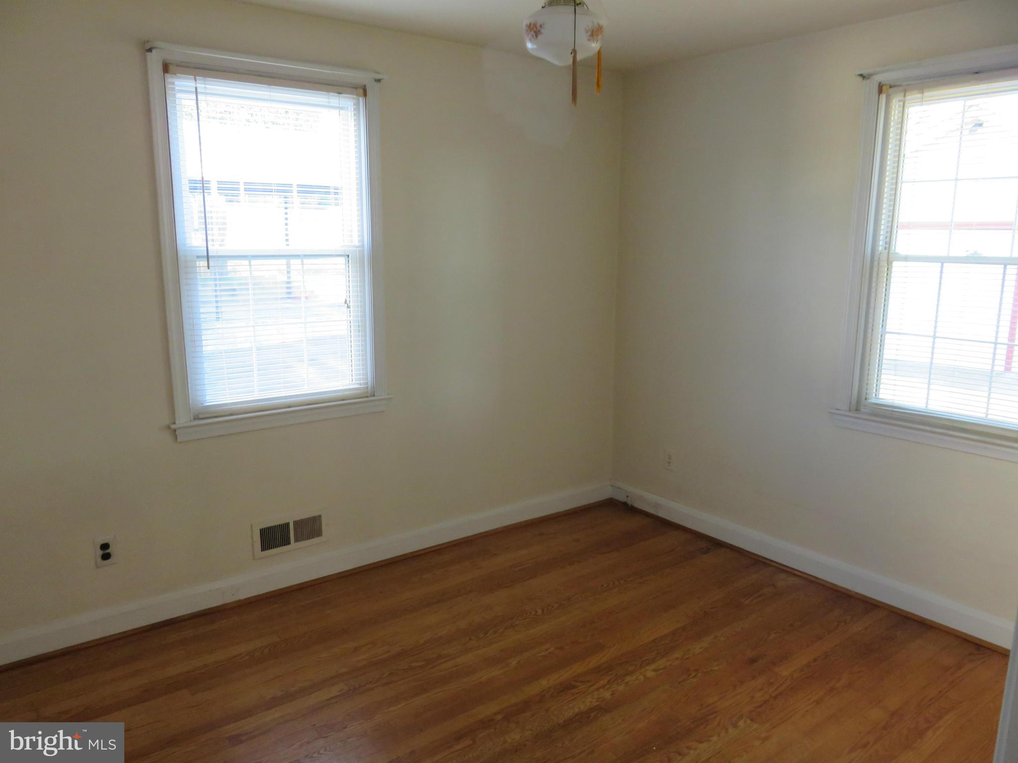 1747 Ellinwood Road Baltimore, MD 21237 - Photo 14 of 26 an empty room with wooden floor and windows