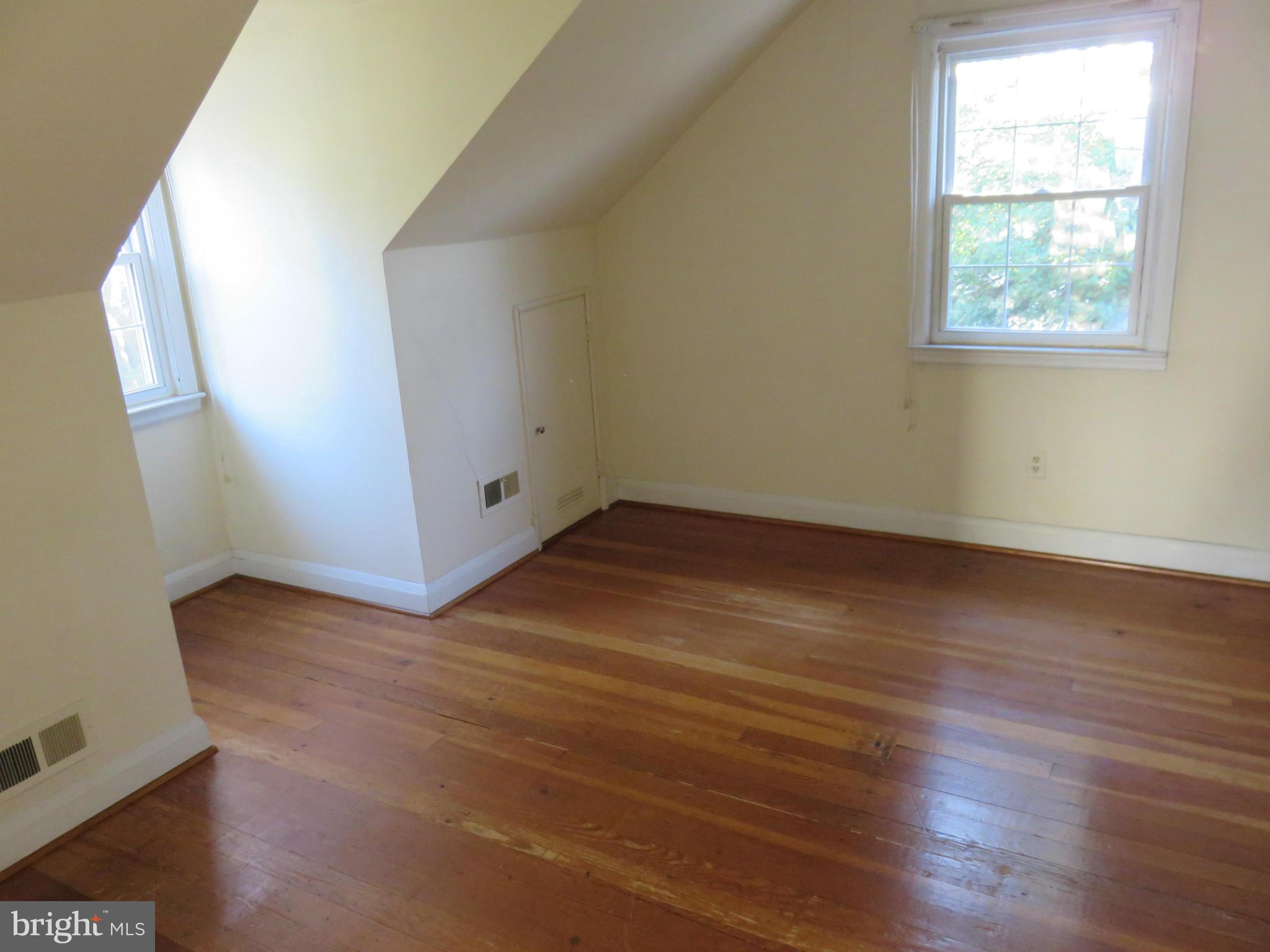 1747 Ellinwood Road Baltimore, MD 21237 - Photo 15 of 26 an empty room with wooden floor and windows