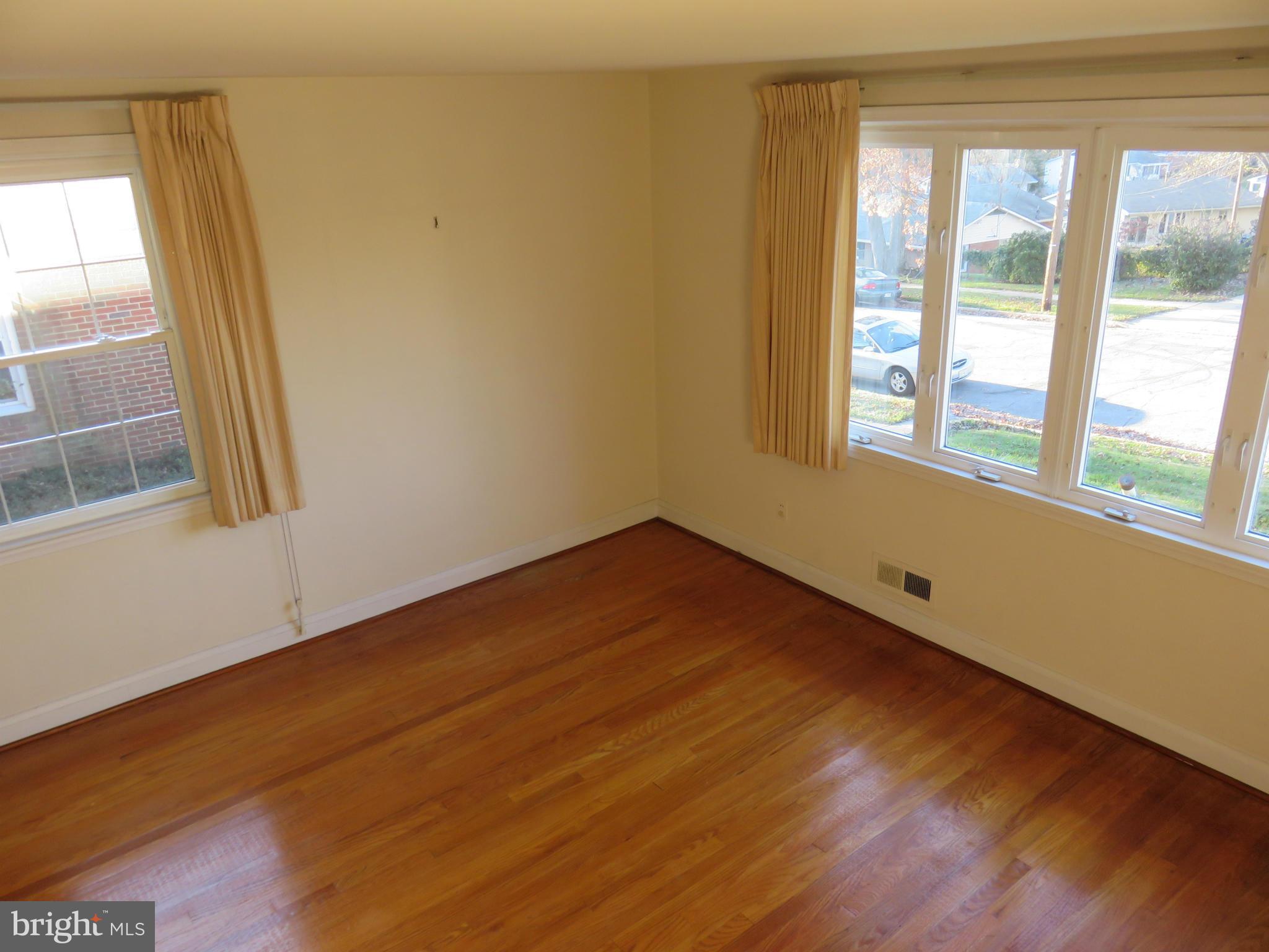 1747 Ellinwood Road Baltimore, MD 21237 - Photo 5 of 26 a view of an empty room with wooden floor and a window