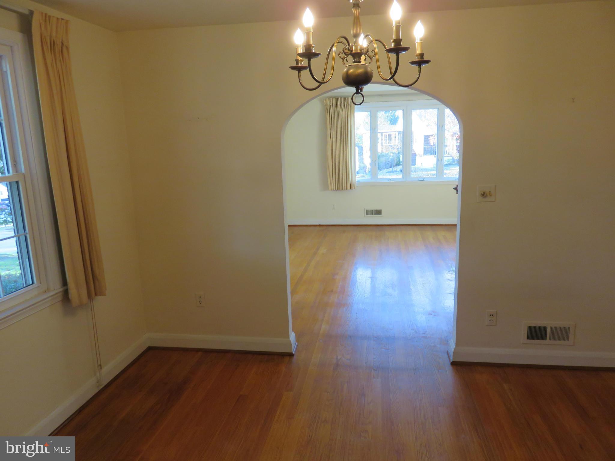 1747 Ellinwood Road Baltimore, MD 21237 - Photo 10 of 26 an empty room with wooden floor chandelier and entryway