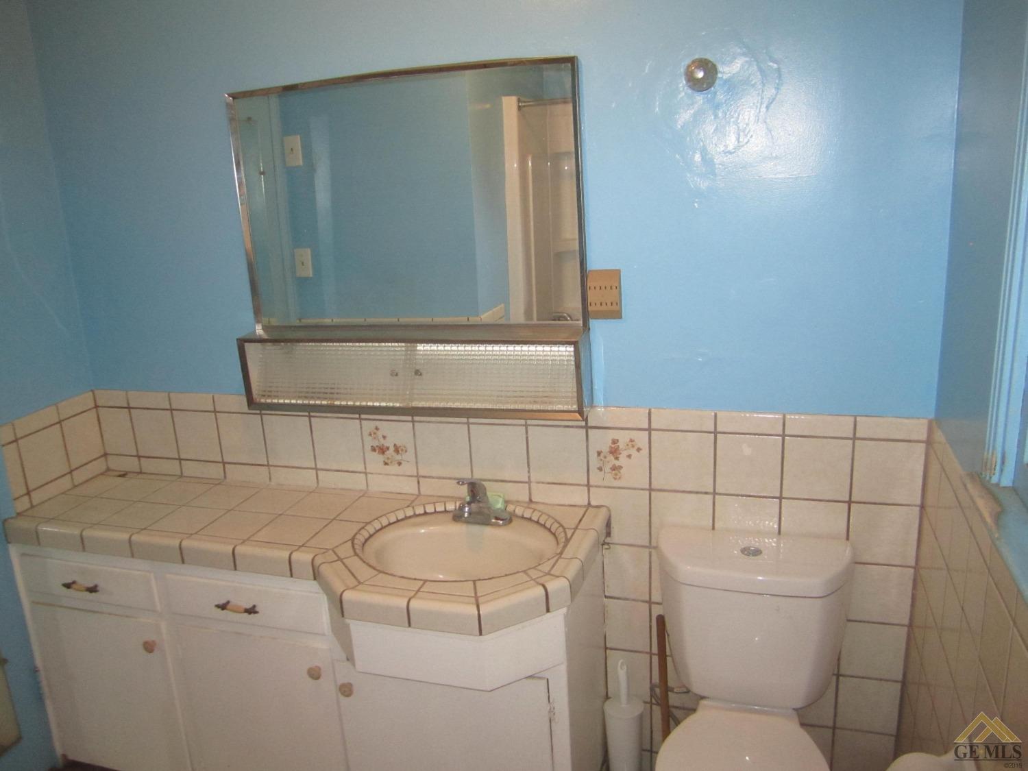 Undisclosed Address Bakersfield, CA 93305 - Photo 10 of 18 a bathroom with a sink toilet and mirror