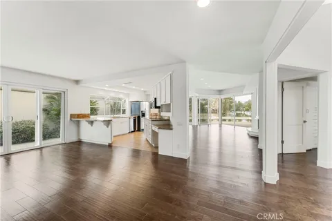 a view of empty room with wooden floor and windows