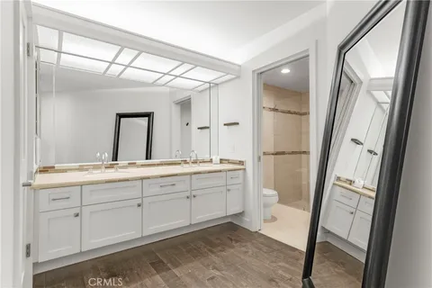 a spacious bathroom with a double vanity sink a toilet and a shower