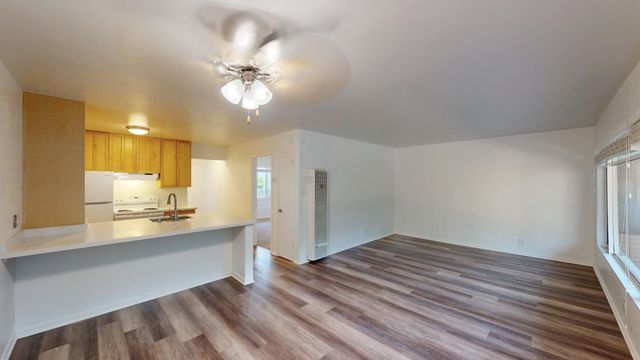 a view of a kitchen with a sink dishwasher a refrigerator and wooden floor