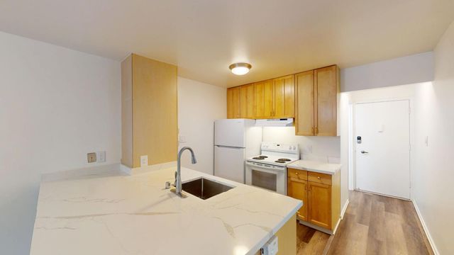 a kitchen with stainless steel appliances a stove a sink cabinets and a refrigerator