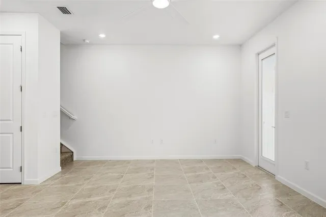 an empty room with windows and fan