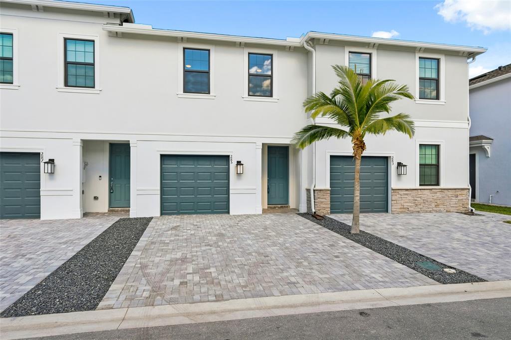 285 Southwest Sally Way Stuart, FL 34997 - Photo 2 of 48 a house that has a palm tree in front of it
