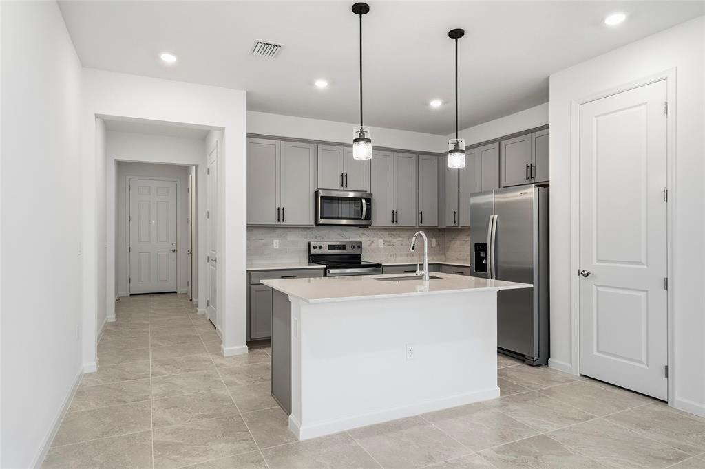 285 Southwest Sally Way Stuart, FL 34997 - Photo 3 of 48 a kitchen with stainless steel appliances granite countertop a refrigerator a sink and a stove