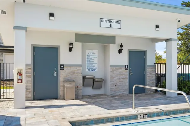 a view of a white house next to a yard with big trees