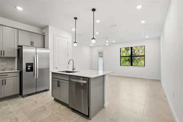 a kitchen with stainless steel appliances granite countertop a sink a stove a refrigerator and island
