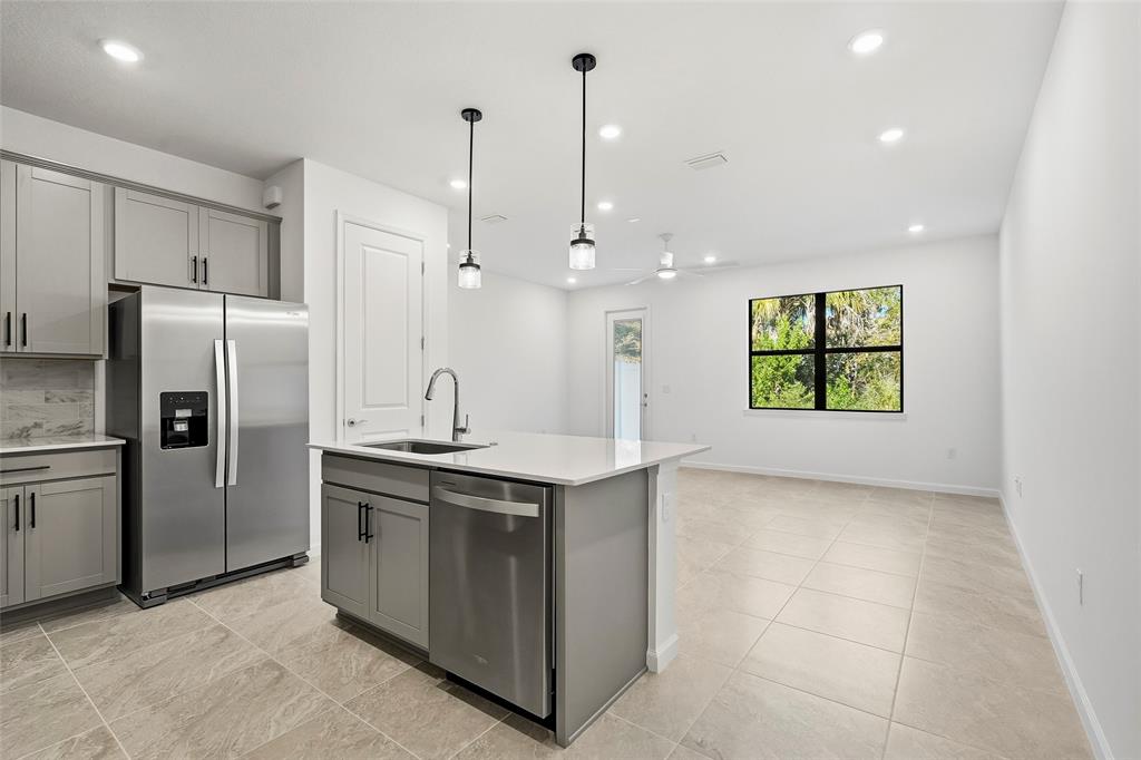 285 Southwest Sally Way Stuart, FL 34997 - Photo 6 of 48 a kitchen with stainless steel appliances granite countertop a sink a stove a refrigerator and island