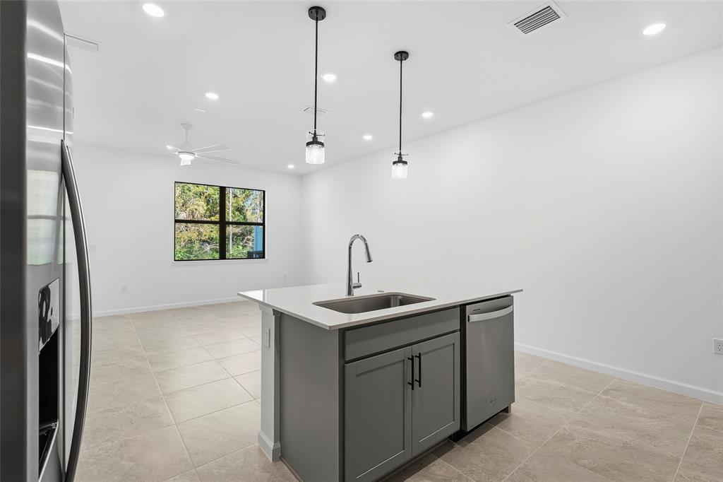 285 Southwest Sally Way Stuart, FL 34997 - Photo 7 of 48 a kitchen with stainless steel appliances granite countertop a sink a window and a wooden floor