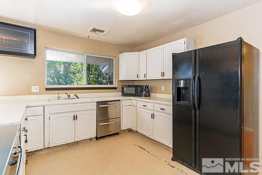 1595 Belford Road Reno, NV 89509 - Photo 7 of 21 a kitchen with white cabinets stainless steel appliances and a window
