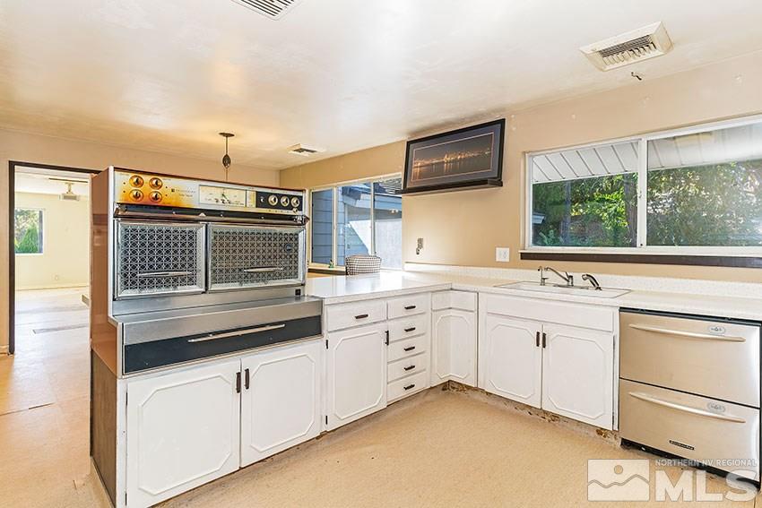 1595 Belford Road Reno, NV 89509 - Photo 8 of 21 a kitchen with granite countertop white cabinets and white appliances