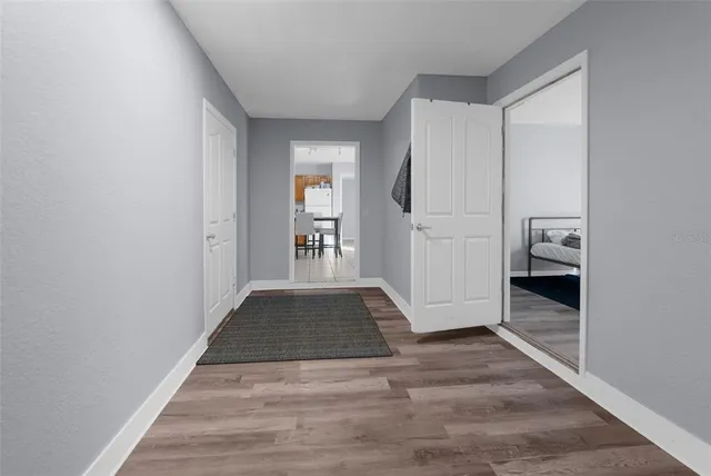 a view of hallway with walk in closet and wooden floor