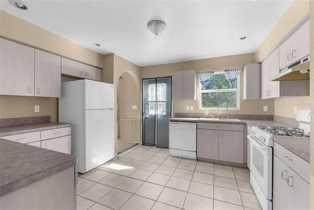 a kitchen with a refrigerator and a stove top oven