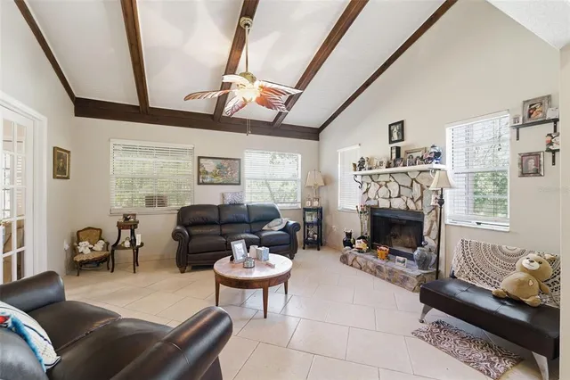 a living room with furniture a fireplace and a floor to ceiling window