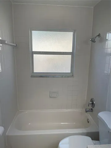 a bathroom with a bathtub window and vanity