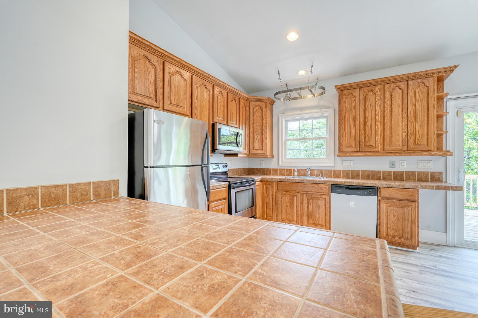 304 South Camp Meade Road Linthicum Heights, MD 21090 - Photo 14 of 43 a kitchen with granite countertop a stove a sink dishwasher a refrigerator and cabinets with wooden floor