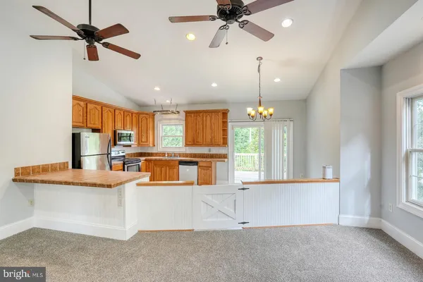 a view of a kitchen with a large window cabinets and a chandelier
