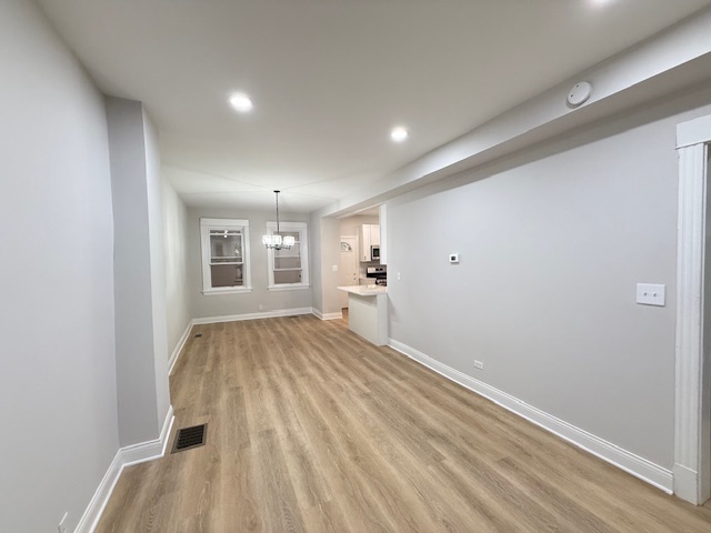 7045 South Prairie Avenue Chicago, IL 60637 - Photo 4 of 11 a view of a room with wooden floor and windows