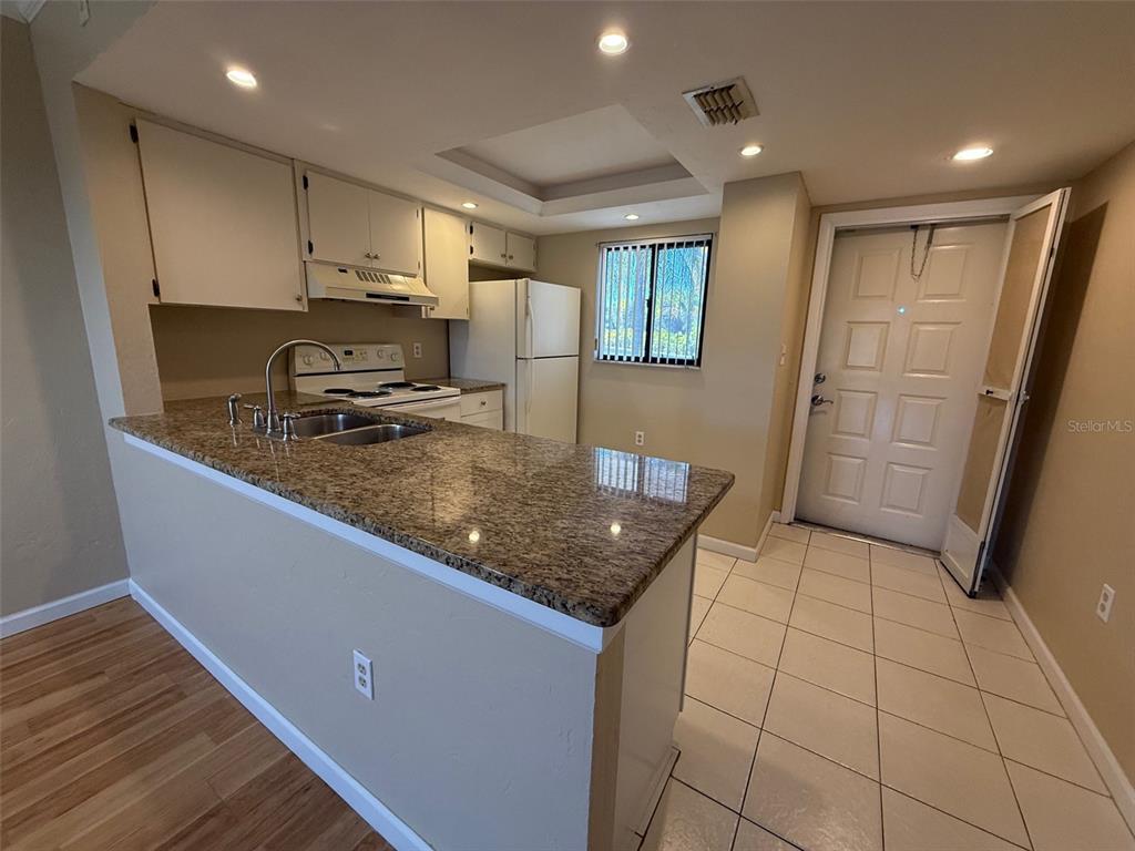 25225 Rampart Boulevard, Unit 1301 Punta Gorda, FL 33983 - Photo 6 of 19 a kitchen with stainless steel appliances granite countertop a refrigerator a sink a stove a microwave and island