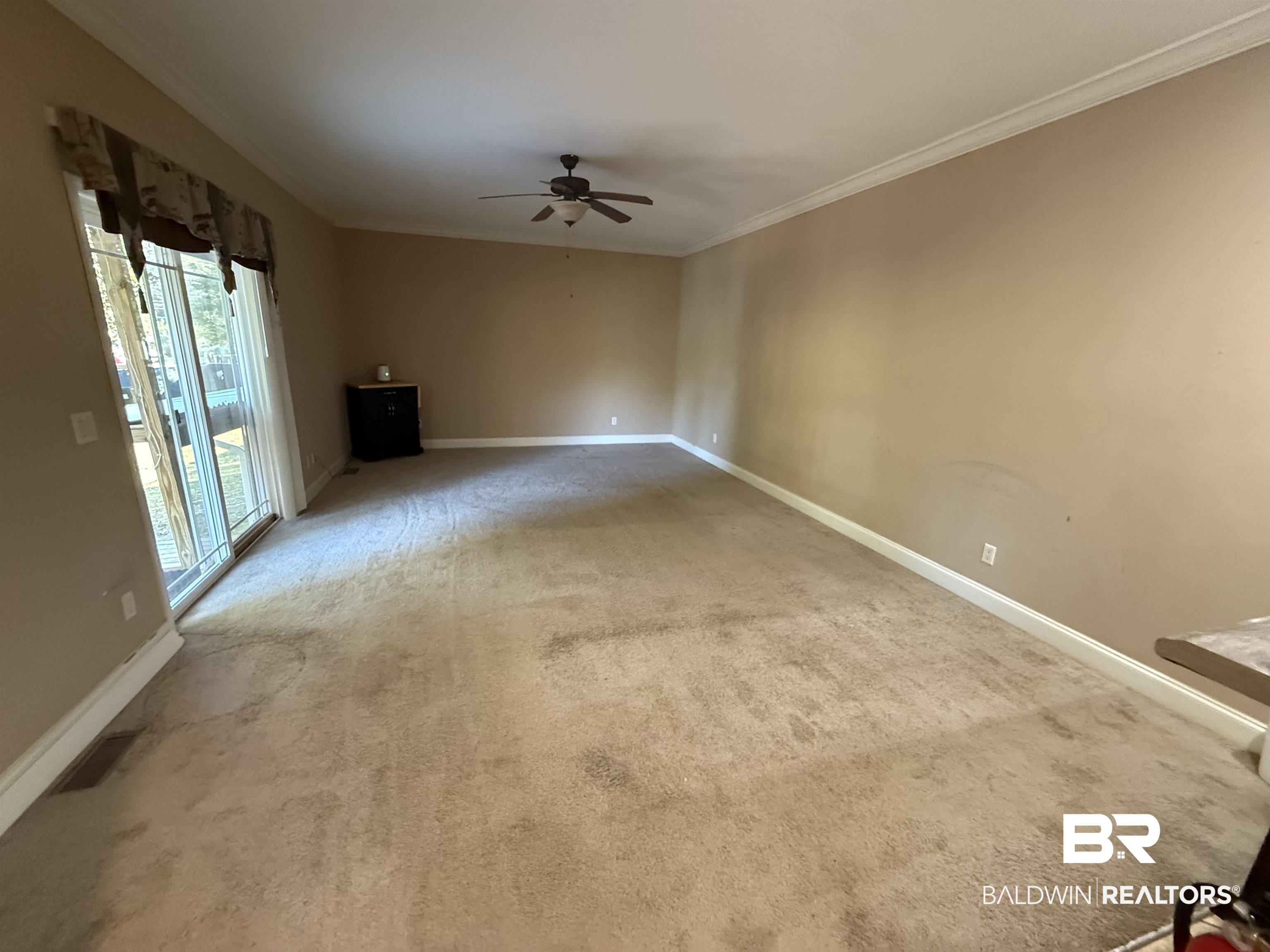 1274 Caney Loop Lillian, AL 36549 - Photo 7 of 19 Unfurnished living room featuring ceiling fan, carpet floors, and ornamental molding