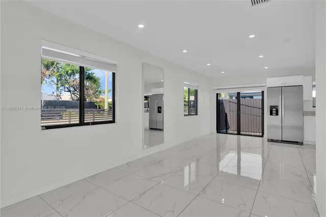 a view of a big room with windows and chandelier