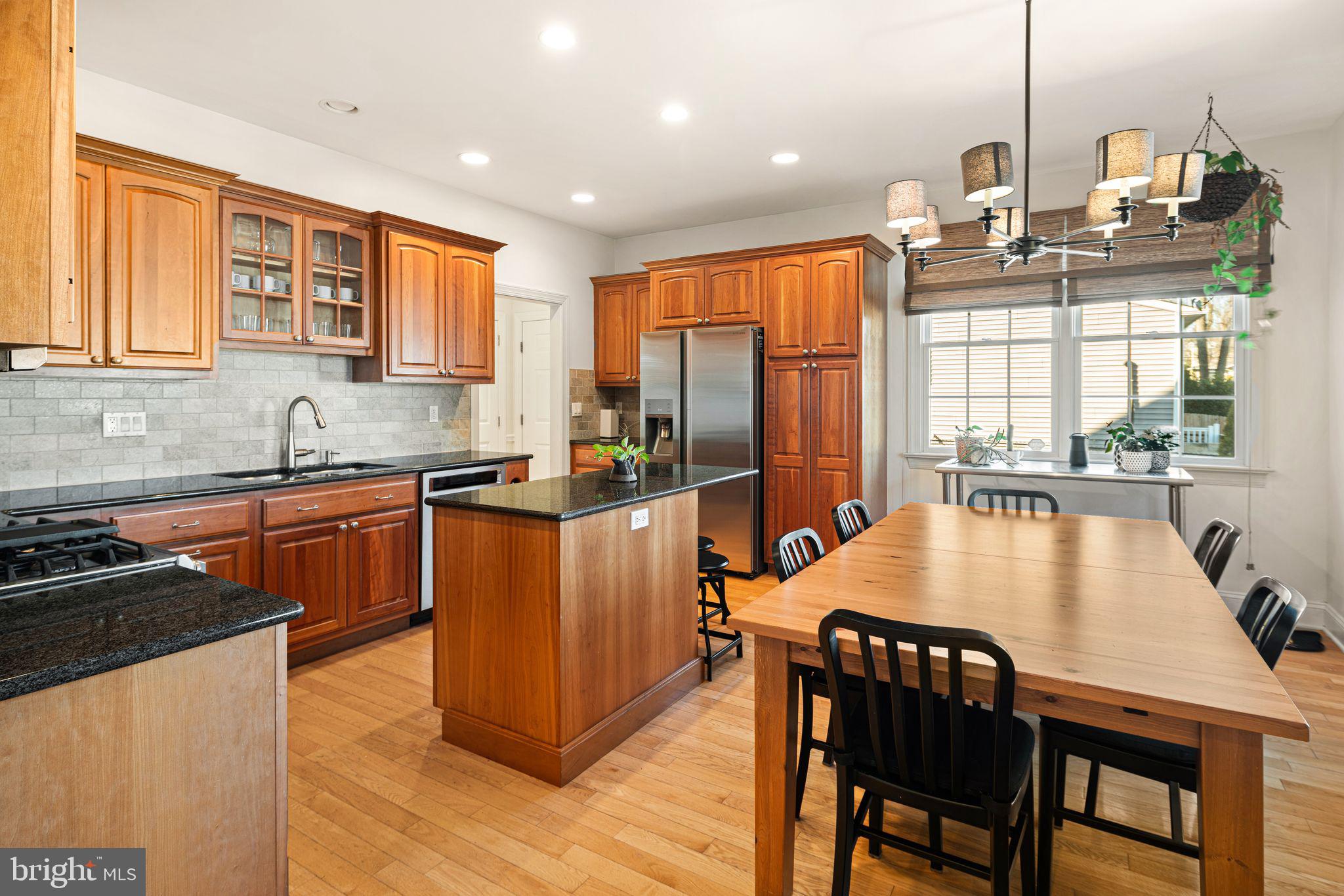 417 East Summit Avenue Haddonfield, NJ 08033 - Photo 5 of 34 a kitchen with stainless steel appliances granite countertop a stove top oven a sink a dining table and chairs with wooden floor