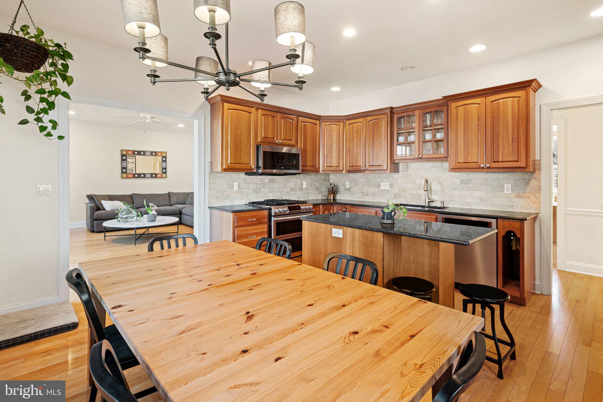 417 East Summit Avenue Haddonfield, NJ 08033 - Photo 6 of 34 a large kitchen with kitchen island a dining table chairs and a refrigerator