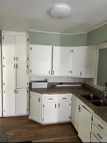 a kitchen with granite countertop a sink and cabinets