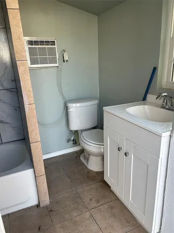 a bathroom with a granite countertop toilet and a sink