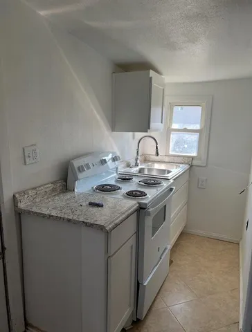 a kitchen with a sink stove and cabinets
