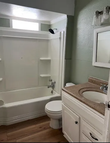 a bathroom with a granite countertop toilet a sink and bathtub