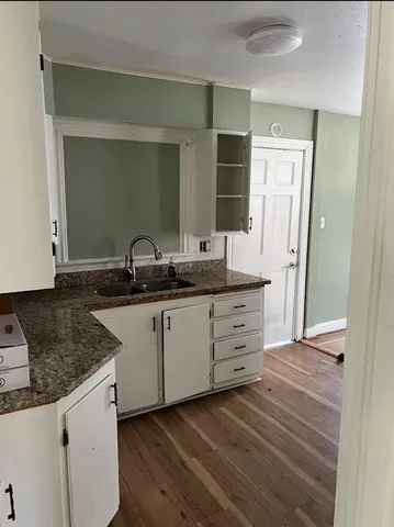 a kitchen with granite countertop a sink and a stove