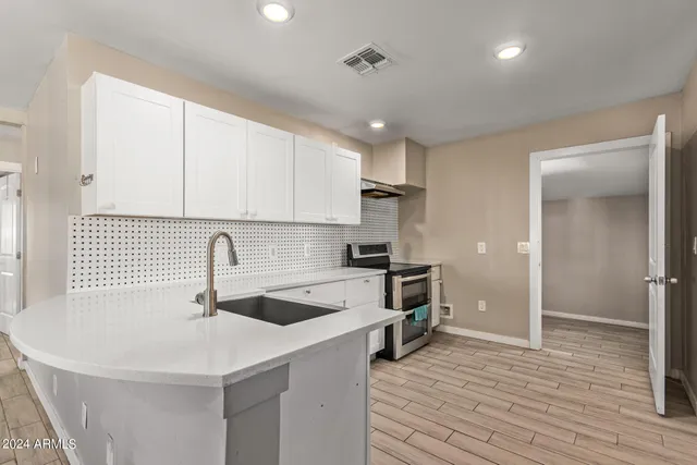 a kitchen with a sink a stove a refrigerator and cabinets