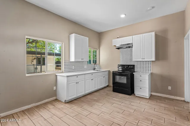 a kitchen with granite countertop a stove sink and cabinets