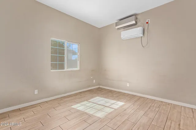 an empty room with a white cabinet and windows
