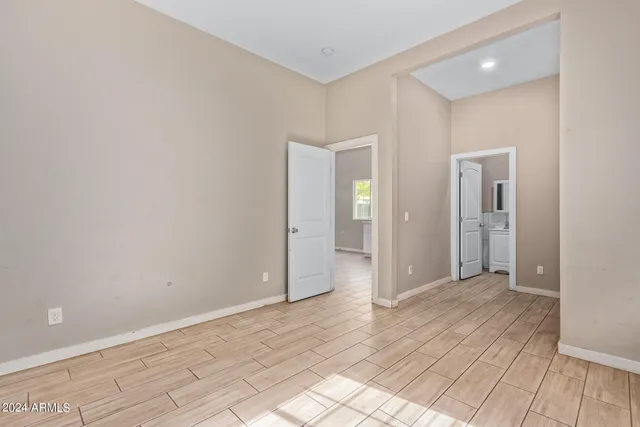 an empty room with wooden floor and mirror