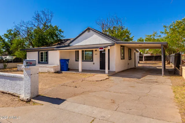 a view of an empty room with wooden floor and a bathroom