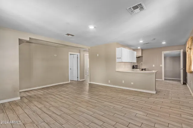 a view of kitchen with kitchen island stainless steel appliances cabinets and wooden floor